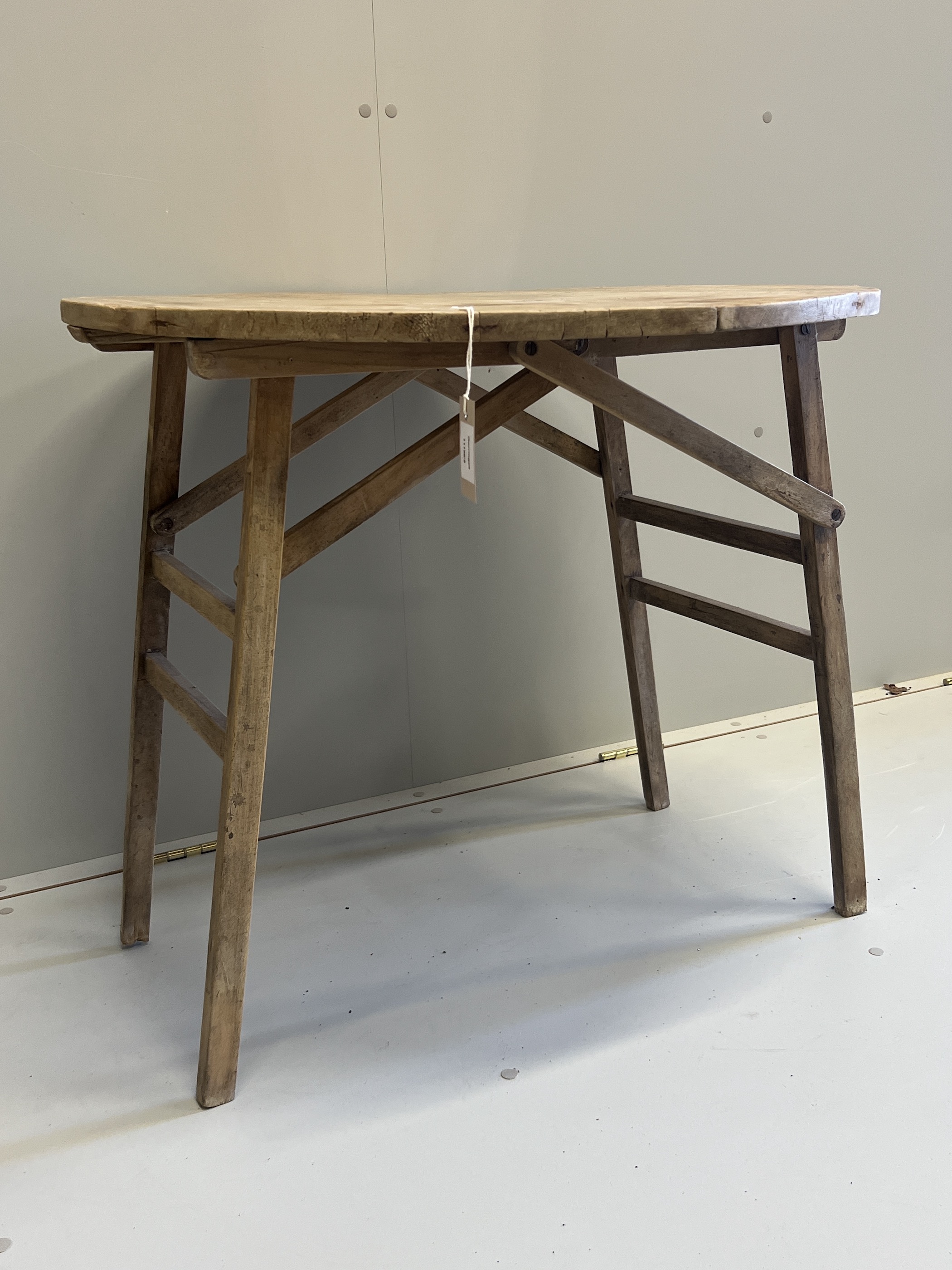 A 19th century French circular pine folding occasional table, diameter 75cm, height 68cm